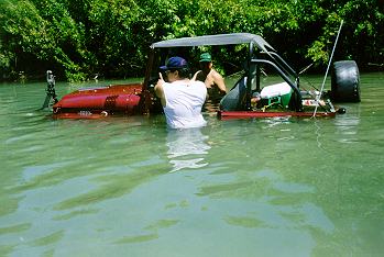 [Jeep in river three feet deep with wondering people alongside]